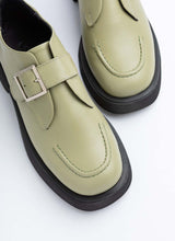 Load image into Gallery viewer, Ein Paar Lederhalbschuhe mit verstellbarer Monk-Schnalle des Herstellers Cedoublé. Das nicht geschlechterspezifische Modell ist in einem hellen Maigrün, das Obermaterial ist hochwertiges Glattleder. Die leicht abgerundete Karree-Schuhfront sowie die dezente Plateausohle lassen den Schuh avantgardistisch wirken.