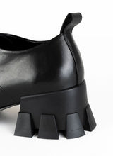 Lade das Bild in den Galerie-Viewer, Produktbild eines schwarzen Schnürschuhs mit Karree Leisten und Anziehlasche. Im Fokus des Bildes steht der markante, skulpturale Absatz mit breiter Auftrittsfläche und Profil. Der Absatz ist ca. 5,5 cm hoch.