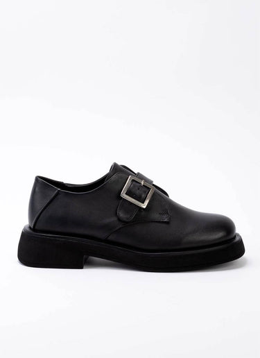 Klassisch-cooler Unisex-Schuhs aus zeitlosem, schwarzem Leder mit Riemen und Schnalle, die Schuhspitze ist eine Mischung aus Karree und rund.