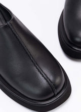 Load image into Gallery viewer, Nahaufnahme der Schuhfront eines coolen Clog-Modells aus schwarzem, zertifiziertem Echtleder. Gut zu sehen ist das Design-Detail, eine raffinierte Wulstnaht, die den Schuhschaft optisch in zwei Seiten unterteilt. 
