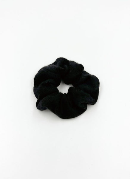 Haargummi aus reinem Cashmere-Strick in schwarz. Es handelt sich um ein luxuriöses Accessoire für die Haare.