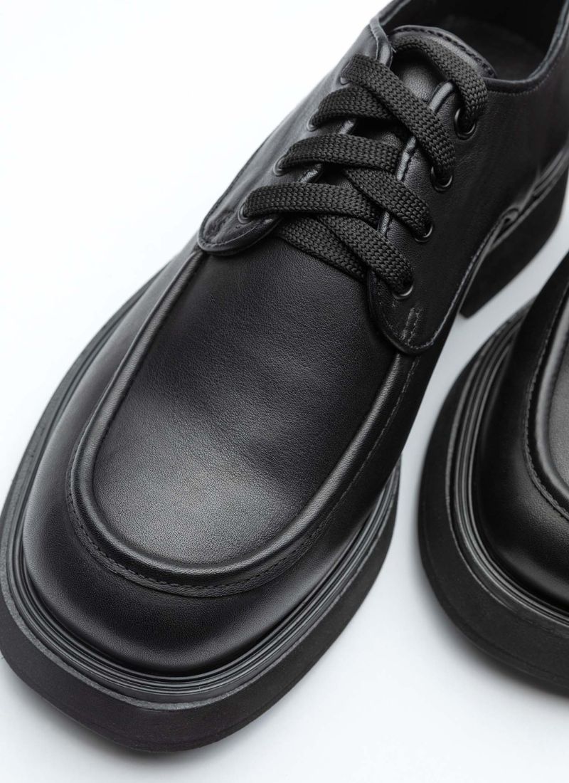  Schwarzer, klassischer Halbschuh aus Leder mit Schnürung. Das Modell ist insgesamt zeitlos und schlicht gehalten, hat aber durch die ebenfalls schwarze Lederpaspel ein ausgereiftes Design. Der Schuh ist für Frauen und Männer gleichermaßen gut tragbar.