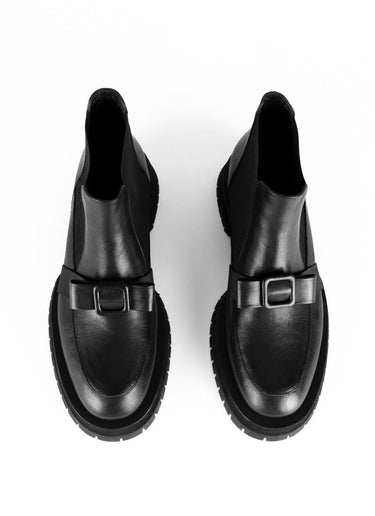 Chelseaboot aus Leder in schwarz mit dekorativem Schleifendetail, welches sich über den Spann schmiegt. Eine ausgeprägte Laufsohle umrahmt den Schaft und schafft einen Kontrast zu dem verspielt-femininen Schleifendekor.