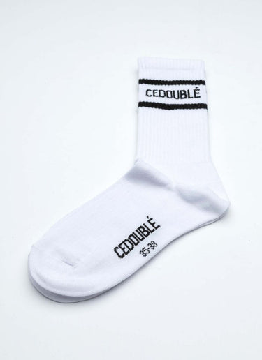 Produktfoto einer Tennissocke aus organic cotton in weiß mit schwarzen Details wie dem Logo des Herstellers Cedoublé. Tragbar für alle Geschlechter. Die Socke hat eine mittlere Länge.